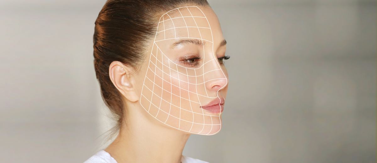 Frau mit digitalem Gitter auf dem Gesicht – Symbol für Hautanalyse und Anti-Aging-Pflege