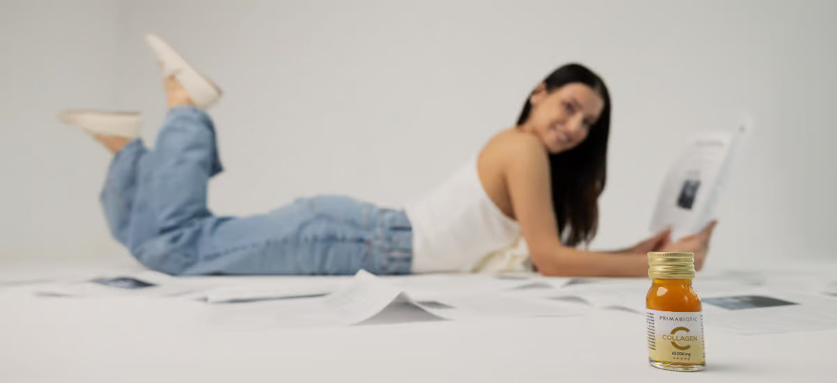 Die neue Primabiotic Koleganformel und im Hintergrund eine Frau, die eine Zeitung liest.