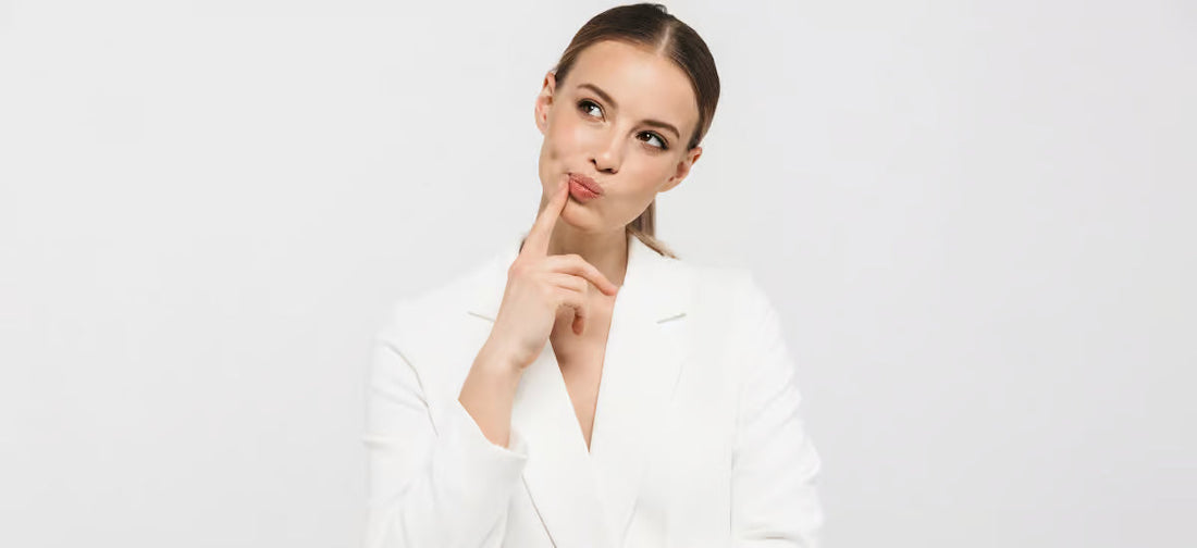 Eine Frau in einem weißen Blazer mit einem nachdenklichen Gesichtsausdruck