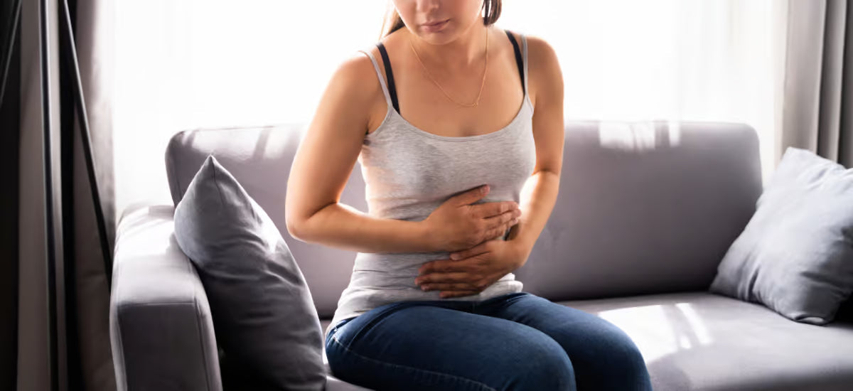 Frau hält sich aufgrund von PMS den Bauch