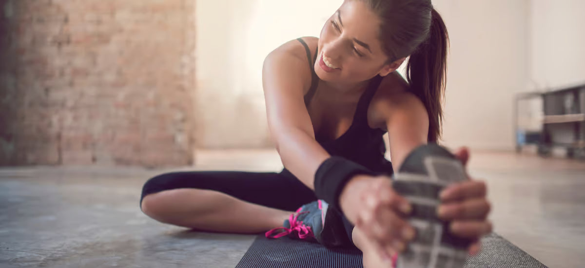 Eine Frau dehnt sich auf einer Matte