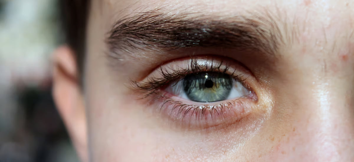 Eine Frau, die mit einem Auge in die Linse schaut.