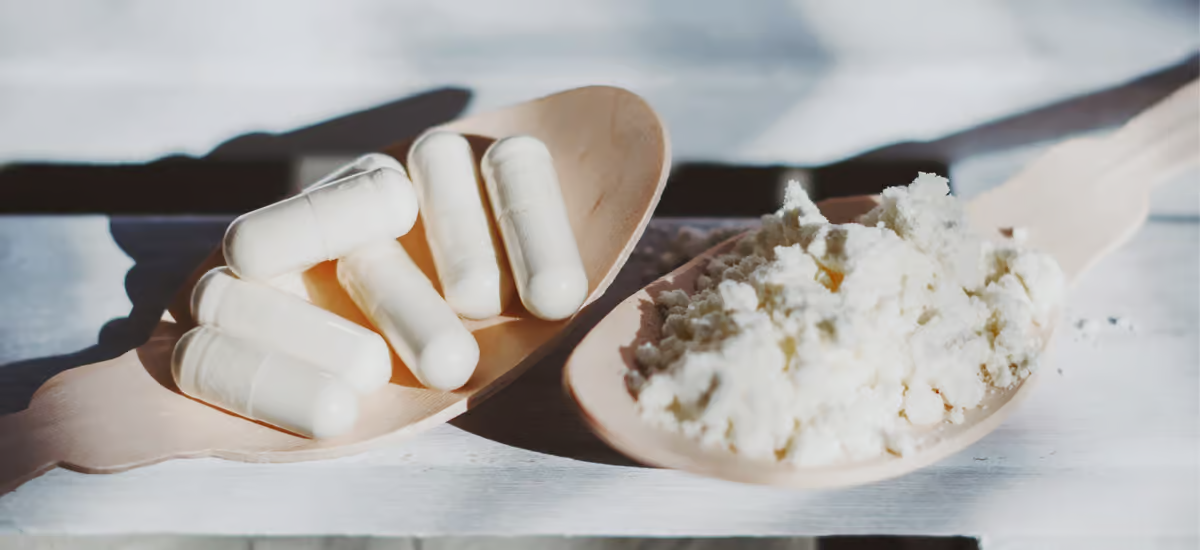 Colostrum Pulver und Tabletten auf Löffeln|