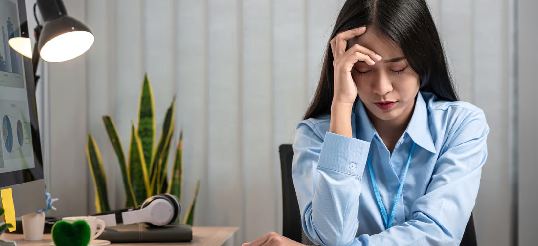 Gestresste Frau hält sich den Kopf