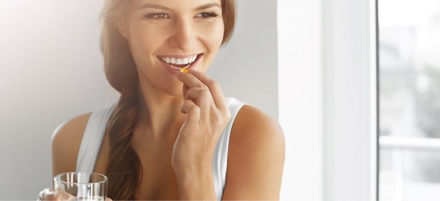 Frau die eine Ergänzung einnimmt