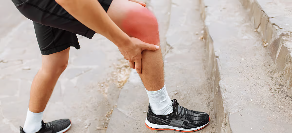 Person hält sich am Knie fest