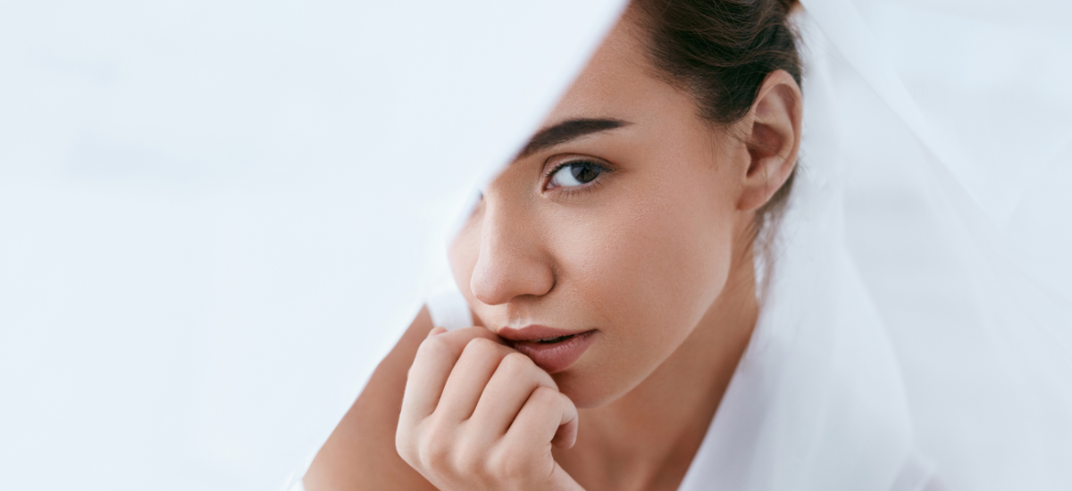 Porträt einer Frau mit sanftem Blick, teilweise unter Schleier verborgen