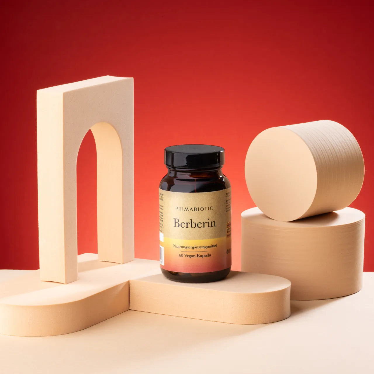 Verpackung Berberin von Primabiotic auf beigen Podesten vor rotem Hintergrund.