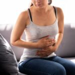 Frau hält sich aufgrund von PMS den Bauch