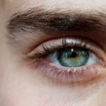 Eine Frau, die mit einem Auge in die Linse schaut.